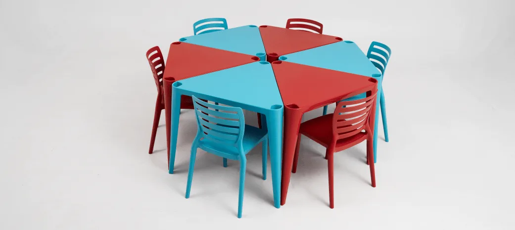 mesa e cadeiras produzida com plástico reciclagem, nas cores azul e vermelho, comprovam como a economia circular funciona na prática